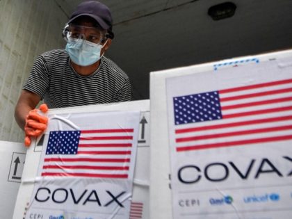 A worker unloads boxes from the consignment of the Pfizer-BioNTech vaccines against the Covid-19 Coronavirus donated to Nepal by the US government at a cold storage facility in Kathmandu on October 25, 2021.
