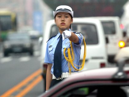 A Chinese traffic policewoman points to a driver making a wrong turn in the northeastern port city of Dalian 21 July 2003, which is hosting the Asia Europe Meeting (ASEM) of economic ministers in China. The aftermath of the SARS epidemic, North Korea and a new global round of trade …