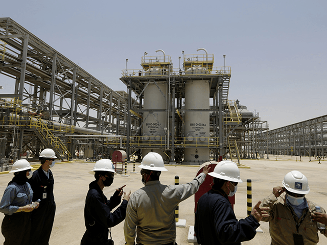 In this June 28, 2021, file photo, Saudi Aramco engineers and journalists look at the Hawiyah Natural Gas Liquids Recovery Plant, which is designed to process 4.0 billion standard cubic feet per day of sweet gas, a natural gas that does not contain significant amounts of hydrogen sulfide, in Hawiyah, …