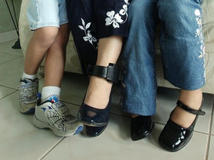 HOLLYWOOD, UNITED STATES: Wearing an electronic bracelet on her left ankle, Lourdes Sandivar poses for a photograph with her six-year old daughter Shirley (L) and with her five-year old son Kevin (R) at her apartment 17 January 2003 in Hollywood, Florida. Sandivar is awaiting deportation with her husband Jose in …