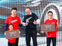 Tesla CEO Elon Musk (C) poses for photos with buyers during the Tesla China-made Model 3 D