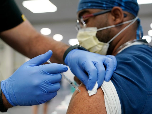 In this Oct. 5, 2021, file photo, a healthcare worker receives a Pfizer COVID-19 booster shot at Jackson Memorial Hospital in Miami. The number of Americans getting COVID-19 vaccines has steadily increased to a three-month high as seniors and people with medical conditions seek boosters, and government and employer mandates …
