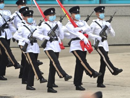 Hong Kong Police officers goose-step carrying the Chinese and Hong Kong flags during a flag-raising ceremony to mark the 24th anniversary of Hong Kong's handover from Britain in Hong Kong on July 1, 2021. (Photo by Peter PARKS / AFP) (Photo by PETER PARKS/AFP via Getty Images)