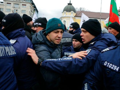 Policemen push protesters away from the Bulgarian Parliament building in Sofia, Wednesday, Jan. 12., 2022. Protesters opposing COVID-19 restrictions in Bulgaria have clashed with police as they were trying to storm the Parliament in Sofia. Heavy police presence prevented protesters from entering the building and some were detained. (AP Photo/Valentina …