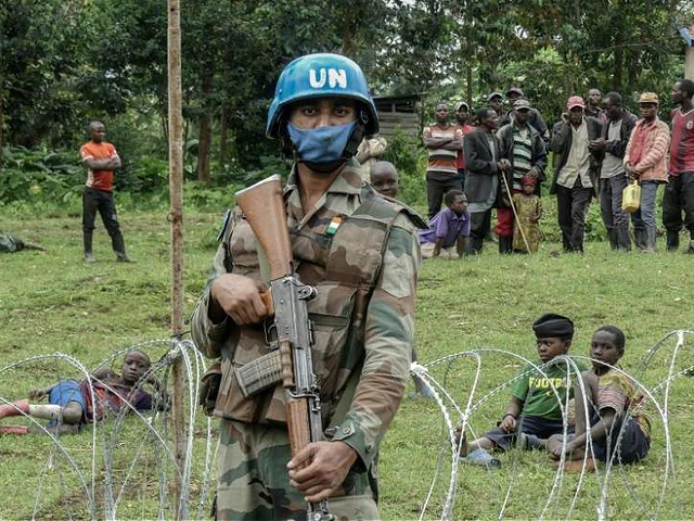 A peacekeeper holds his weapon during a patrol around the new base set up in Rugari, 50 km from the city of Goma, as the population watches the military in eastern Democratic Republic of Congo on January 28, 2022. - At the foot of the extinct volcano Mikeno, in eastern Democratic Republic of Congo, entire villages are deserted. Their inhabitants fled violent clashes this week between the army and the ex-rebels of the "M23", which would have killed around thirty soldiers. (Photo by Glody MURHABAZI / AFP) (Photo by GLODY MURHABAZI/AFP via Getty Images)
