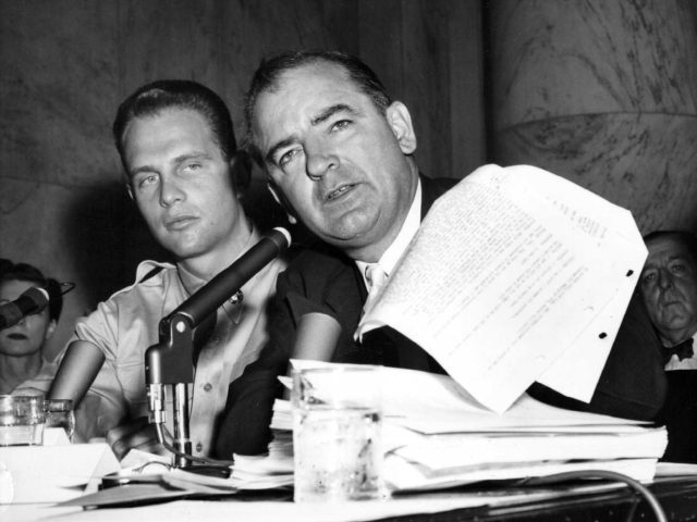 Senator Joe McCarthy is seen here waving a transcript of a monitored call between Pvt. G. David Schine (L) and Army Secretary Stevens, during the Army-McCarthy hearings, June 7, 1954 in Washington D.C. Schine appeared to listen to the transcript as it was read into the record. On the right …