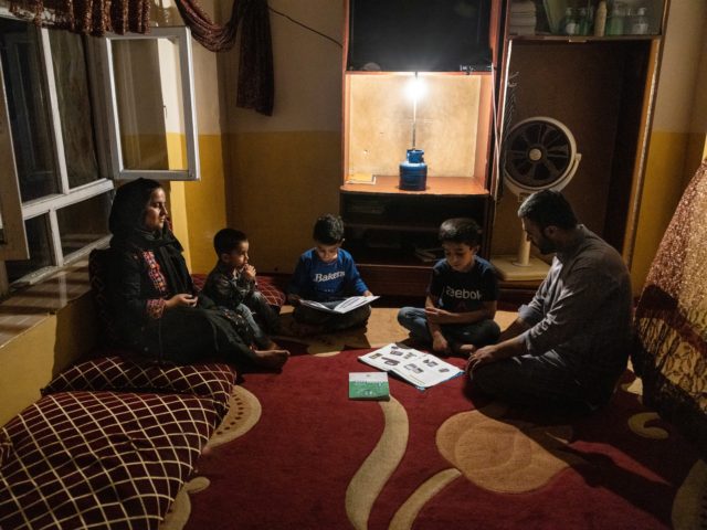 KABUL, AFGHANISTAN - JULY 30: Yousef Mohammed, 35, sits with his three sons using a gas lamp while they do their homework during one of the many power outages on July 30, 2021 in Kabul, Afghanistan. He worked as a combat translator for the US army for 5 years from …