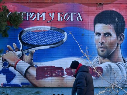 A local resident walks past a mural depicting Serbian tennis player Novak Djokovic in Belg
