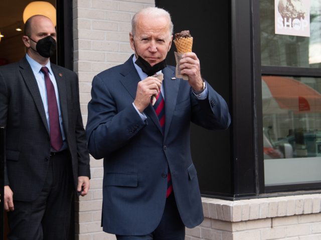 US President Joe Biden carries an ice cream cone as he leaves Jeni's Ice Cream in Washingt