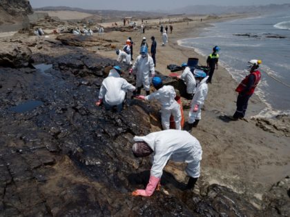 Cleaning crews work to remove oil from a beach in the Peruvian province of Callao on January 17, 2022, after a spill which occurred during the unloading process of the Italian-flagged tanker "Mare Doricum" at La Pampilla refinery caused by the abnormal waves recorded after the volcanic eruption in Tonga. …