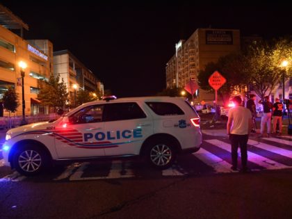 A police car blocks a street near the Nationals Park stadium as the game between the Washington Nationals and the San Diego Padres was suspended due to a shooting outside the ballpark in Washington, DC, on July 17, 2021. - Four people were shot outside a baseball stadium crowded with …