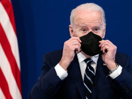 WASHINGTON, DC - JANUARY 13: U.S. President Joe Biden holds a mask as he gives remarks on his administration's response to the surge in COVID-19 cases across the country from the South Court Auditorium in the Eisenhower Executive Office Building on January 13, 2022 in Washington, DC. During the remarks …