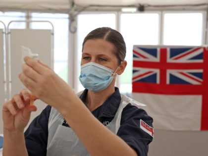 Royal Navy medics prepare syringes ahead of giving injections of the Oxford/AstraZeneca Covid-19 vaccine to members of the public at a vaccination centre set up at Bath racecourse in Bath, southwest England on January 27, 2021. - Over 30 new coronavirus vaccination centres were set to open around England this …