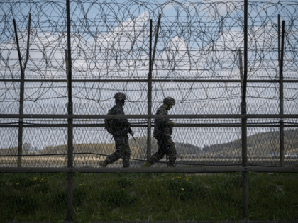 South Korean soldiers patrolling along a barbed wire fence at the Demilitarized Zone with North Korea
