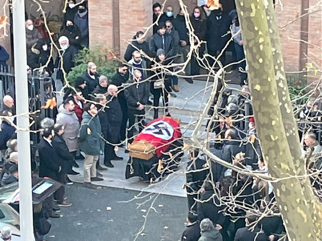 A picture made available by the Italian online news portal Open, showing people gathered around a swastika-covered casket outside the St. Lucia church, in Rome, Monday, Jan. 10, 2022. The Catholic Church in Rome on Tuesday, Jan. 11, 2022, strongly condemned as "offensive and unacceptable" a funeral procession outside a …