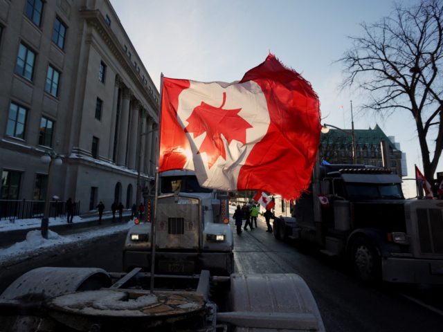 A Canadian flag flies upside down on the back of a truck during a "Freedom Convoy" protesting against COVID-19 vaccine mandates and restrictions in front of the Parliament of Canada on January 28, 2022 in Ottawa, Canada. - A convoy of truckers started off from Vancouver on January 23, 2022 …