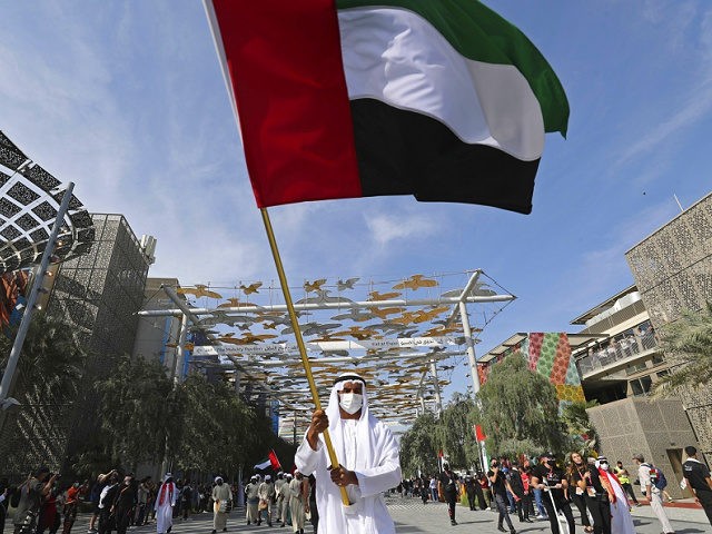 FILE - A man waves the national flag during celebrations for the UAE 50th National Day, at the EXPO 2020 Dubai, in Dubai, United Arab Emirates, Dec. 2, 2021. The multibillion-dollar world’s fair in Dubai warned Tuesday, Dec. 28, 2021, that some venues on site may shut down temporarily as …