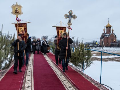 KARLIVKA, UKRAINE - JANUARY 19: A religious procession outside the Holy Epiphany Church on Orthodox Epiphany on January 19, 2022 in Karlivka, Ukraine. The holiday celebrates the baptism of Jesus for Orthodox Christians, who plunge into the icy water to symbolically wash away their sins on a day when it …