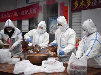 In this photo released by China's Xinhua News Agency, volunteers wearing protective suits package meals for delivery to people under lockdown in Xi'an in northwestern China's Shaanxi Province, Tuesday, Jan. 4, 2022. Hospital officials in the northern Chinese city of Xi'an have been punished after a pregnant woman miscarried after …