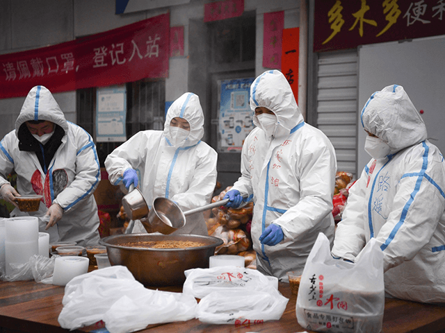 In this photo released by China's Xinhua News Agency, volunteers wearing protective suits