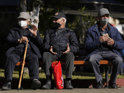 Three elderly men wearing FFP2 face masks to curb the spread of coronavirus, sit on a bench in Athens, Greece, Monday, Jan. 3, 2022. Italy, Spain and other European countries are re-instating or stiffening mask mandates as their hospitals struggle with mounting numbers of COVID-19 patients. (AP Photo/Thanassis Stavrakis, File)