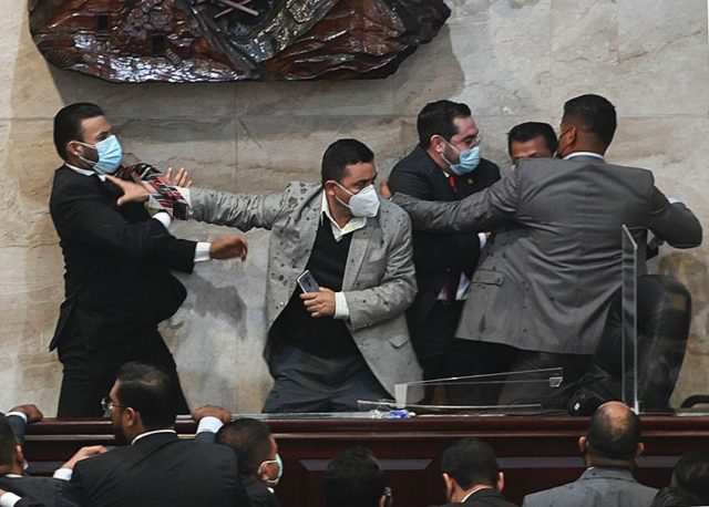 Libre Party lawmaker Rassel Tome (L) tries to attack deputy Jorge Calix (2-R) in Tegucigal