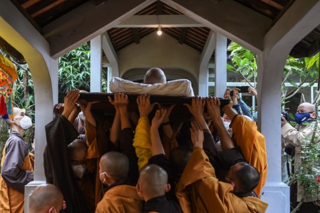 Buddhist monks carry the body of Zen master Thich Nhat Hanh, who died at the age of 95 and