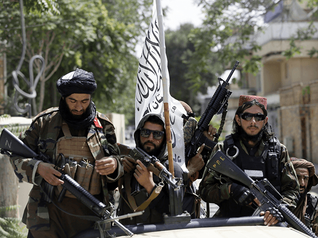 In this Aug. 19, 2021, file photo, Taliban fighters display their flag on patrol in Kabul, Afghanistan. The Taliban win in Afghanistan gave a boost to militants in neighboring Pakistan. The Pakistani Taliban, known as the TTP, have become emboldened in tribal areas along the border with Afghanistan. (AP Photo/Rahmat …
