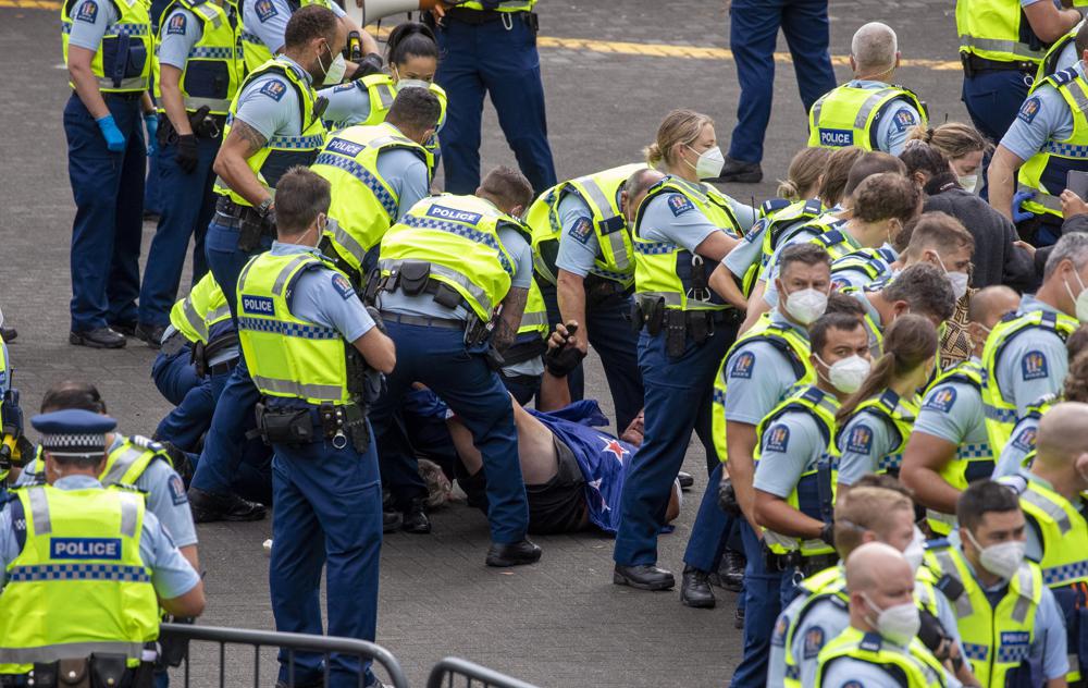 Police arrest people protesting against coronavirus mandates at Parliament in Wellington, New Zealand, Thursday, Feb. 10, 2022. The protest began on Tuesday after more than 1,000 people driving cars and trucks from around the country converged on Parliament in a convoy inspired by protests in Canada and elsewhere around the world. (Mark Mitchell/NZ Herald via AP)