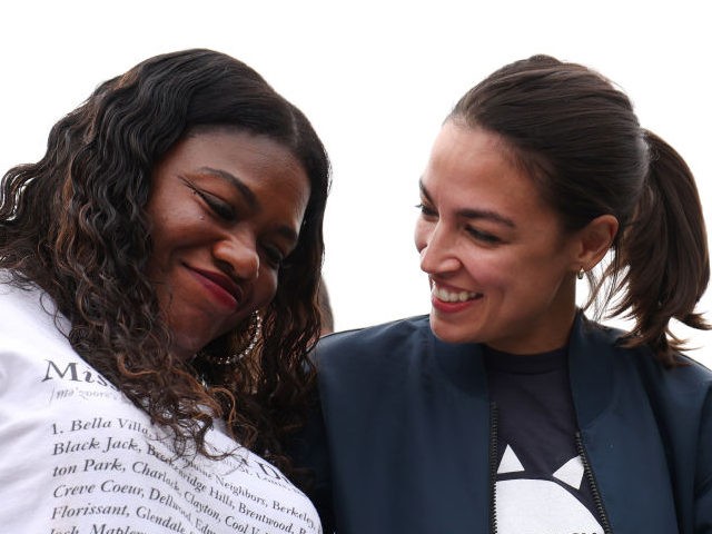 U.S. Reps. Cori Bush (D-MO) (L) and Alexandria Ocasio-Cortez (D-NY) embrace during a rally