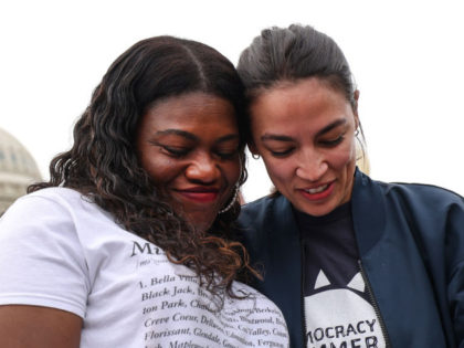 U.S. Reps. Cori Bush (D-MO) (L) and Alexandria Ocasio-Cortez (D-NY) embrace during a rally