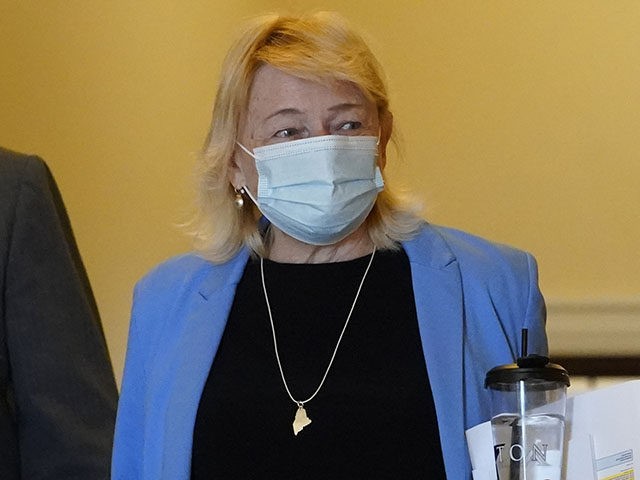 Gov. Janet Mills wears a face covering while walking through the halls of the State House,