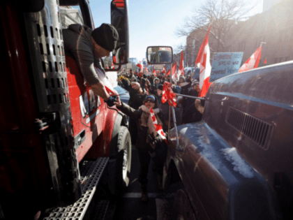 TORONTO, ON - FEBRUARY 05: A supporter shakes the hand of a trucker as a convoy of truckers arrives to a police blockade on February 5, 2022 in Toronto, Canada. A convoy of truckers and supporters have occupied downtown Ottawa since last Saturday in protest of Canadas COVID-19 vaccine mandate, …