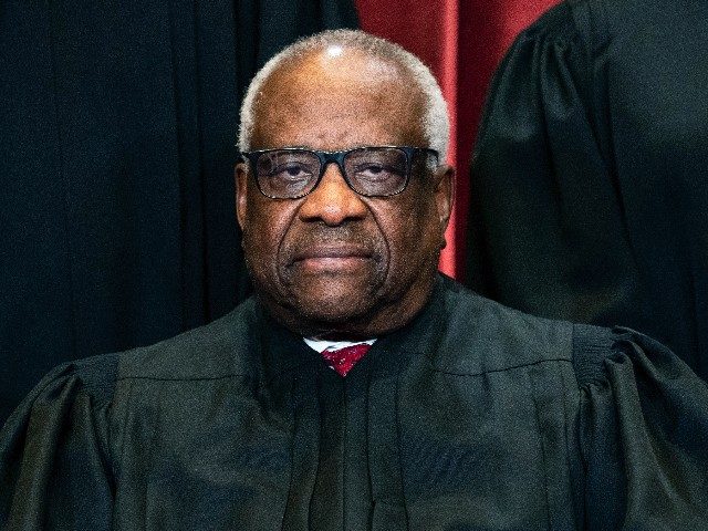 Associate Justice Clarence Thomas sits during a group photo at the Supreme Court in Washin