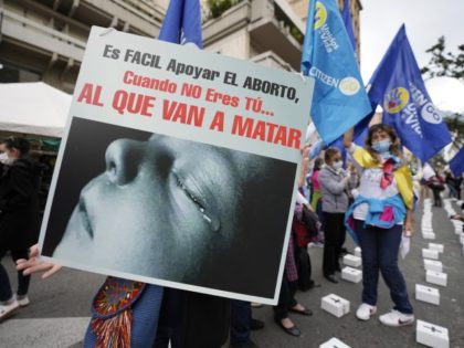 Anti-abortion rights activists protest outside the Constitutional Court as judges continue discussions on the decriminalization of abortion in Bogota, Colombia, Monday, Feb. 21, 2022. The sign reads in Spanish "It's easy to support abortion when it's not you who they are going to kill."