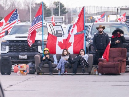 Protestors against Covid-19 vaccine mandates sit on a couch as the group blocks the roadway at the Ambassador Bridge border crossing in Windsor, Ontario, Canada on February 9, 2022. (Photo by Geoff Robins/AFP via Getty Images)