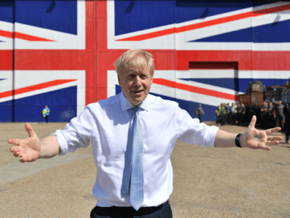 ISLE OF WIGHT, UNITED KINGDOM - JUNE 27: Conservative party leadership contender Boris Johnson poses for a photograph in front of a Union Jack on a wall at the Wight Shipyard Company at Venture Quay during a visit to the Isle of Wight on June 27, 2019 on the Isle …