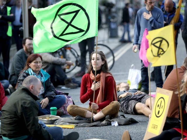 Activists take part in a protest outside Leinster House during the second day of climate change demonstrations by the Extinction Rebellion group, in Dublin, on October 8, 2019. - Climate protesters from Sydney to New York blocked roads Monday, sparking hundreds of arrests, as two weeks of civil disobedience demanding …