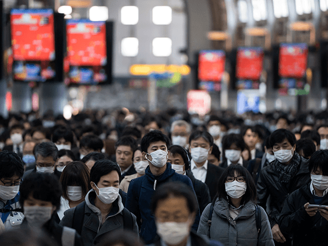 Commuters wearing face masks make their way to work on March 26, 2020 in Tokyo, Japan. Tok
