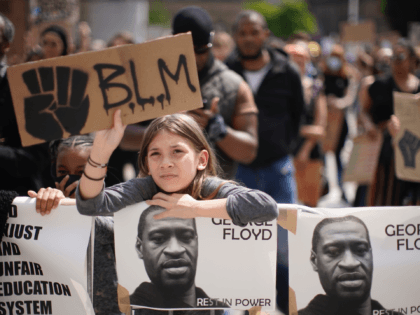 LEEDS, ENGLAND - JUNE 14: A young girl holds up a "BLM" sign during a Black Lives Matter rally in Millennium Square on June 14, 2020 in Leeds, England. Black Lives Matter Rallies continue across the UK following the death on 25 May 2020 of an African American man, George …