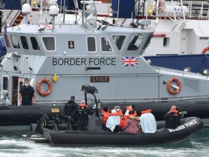 UK Border Force officials travel in a RIB with migrants picked up at sea whilst Crossing the English Channel, as they arrive at the Marina in Dover, southeast England on August 15, 2020. (Photo by Ben STANSALL / AFP) (Photo by BEN STANSALL/AFP via Getty Images)
