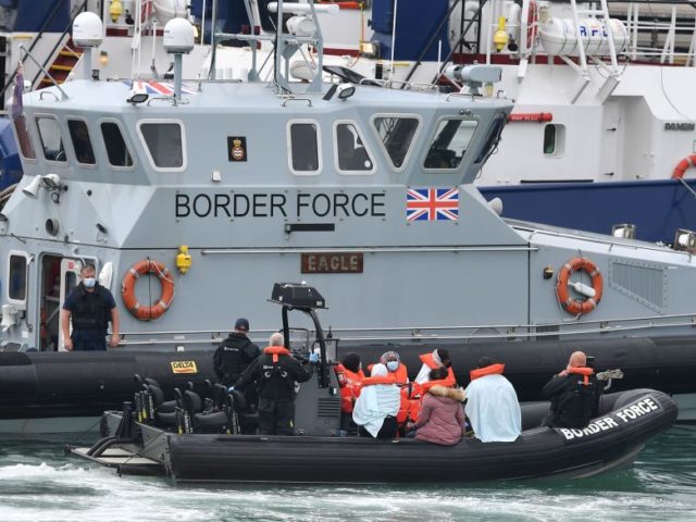 UK Border Force officials travel in a RIB with migrants picked up at sea whilst Crossing t