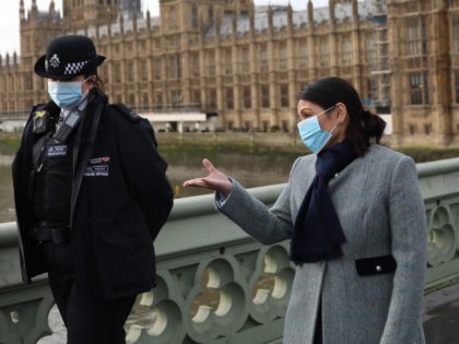 LONDON, ENGLAND - JANUARY 18: British Home Secretary Priti Patel walks across Westminster Bridge toward St Thomas' Hospital with two police officers on January 18, 2021 in London, England. Last week, Ms Patel said that Home Office engineers were working to restore more than 400,000 police records that were accidentally …