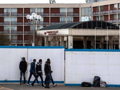 LONDON, ENGLAND - FEBRUARY 24: Asylum seekers exit the Crowne Plaza hotel through an exterior perimeter wall that has been installed whilst they stay at the hotel on February 24, 2021 in London, England. Last week, a group of asylum seekers staying at the Crowne Plaza hotel held a demonstration …