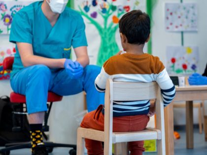 Medical workers follow as pre-school boy uses a newly developed, lollipop-shaped Covid-19 test prior to the testing of pre-schoolers at the 'City of Vienna Kindergarten' in Vienna, Austria on April 28, 2021. - The new lollipop test, a more sensible alternative to other testing options, is being rolled out in …