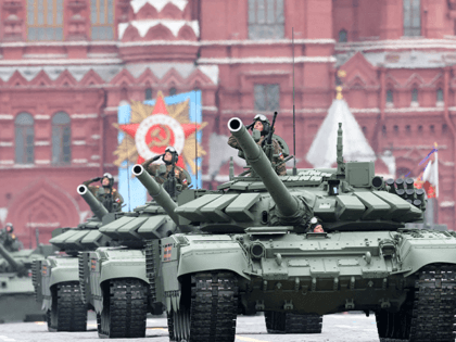 Servicemen salute as their tanks move through Red Square during the Victory Day military p