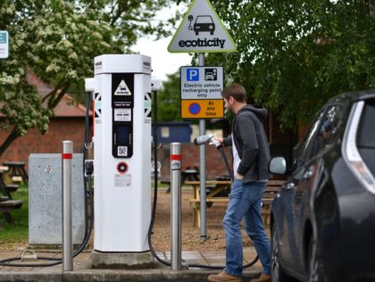 A man charges his vehicle at a recharging point at Maidstone Services on the M20 motorway, south-east of London, on May 24, 2021. - Energy regulator Ofgem has announced on Monday it is investing £300 million to expand the UK's electric vehicle charging network and invest in over 200 low …