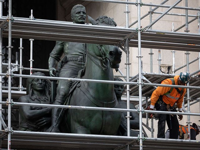 Construction workers erect scaffolding around the statue of US President Theodore Roosevelt at the American Museum of Natural History in New York City on December 2, 2021. - New York has begun the extended process of removing a statue of former US president Theodore Roosevelt, which has been long criticized as a racist and colonialist symbol and became a cultural flashpoint in recent years. The statue depicts Roosevel on horseback with Native American and African American figures standing at his side. (Photo by Yuki IWAMURA / AFP) (Photo by YUKI IWAMURA/AFP via Getty Images)