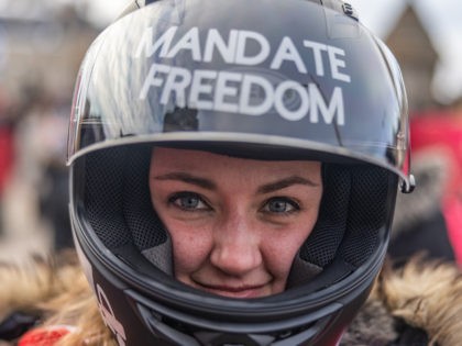 OTTAWA, ON - JANUARY 30: A woman poses for a portrait showing off her biker helmet with the words, "Mandate freedom" written on top on January 29, 2022 in Ottawa, Canada. Thousands turned up over the weekend to rally in support of truckers using their vehicles to block access to …