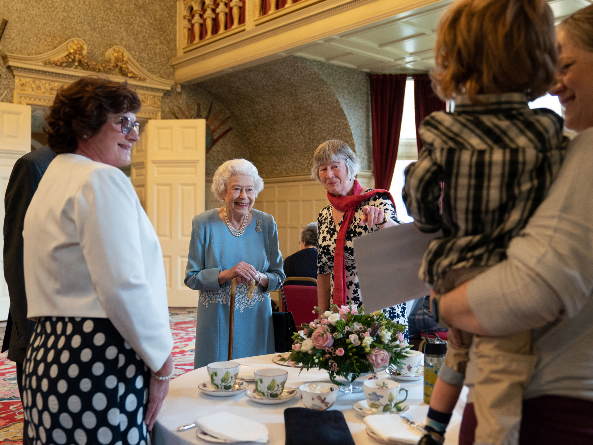 TOPSHOT - Britain's Queen Elizabeth II (centre left) speaks with representatives from local community group Little Discoverers as she celebrates the start of the Platinum Jubilee during a reception in the Ballroom of Sandringham House, the Queen's Norfolk residence on February 5, 2022. - Queen Elizabeth II on Sunday will became the first British monarch to reign for seven decades, in a bittersweet landmark as she also marked the 70th anniversary of her father's death. (Photo by Joe Giddens / POOL / AFP) (Photo by JOE GIDDENS/POOL/AFP via Getty Images)